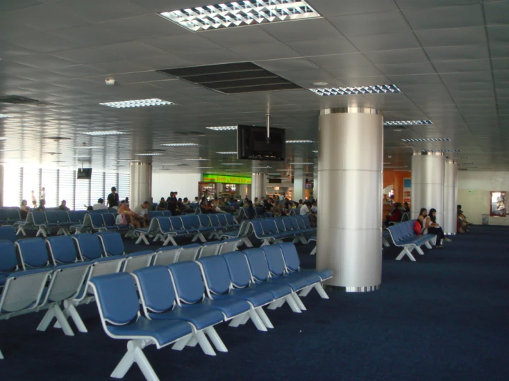 rows of chairs sitting on a blue carpet in an empty room