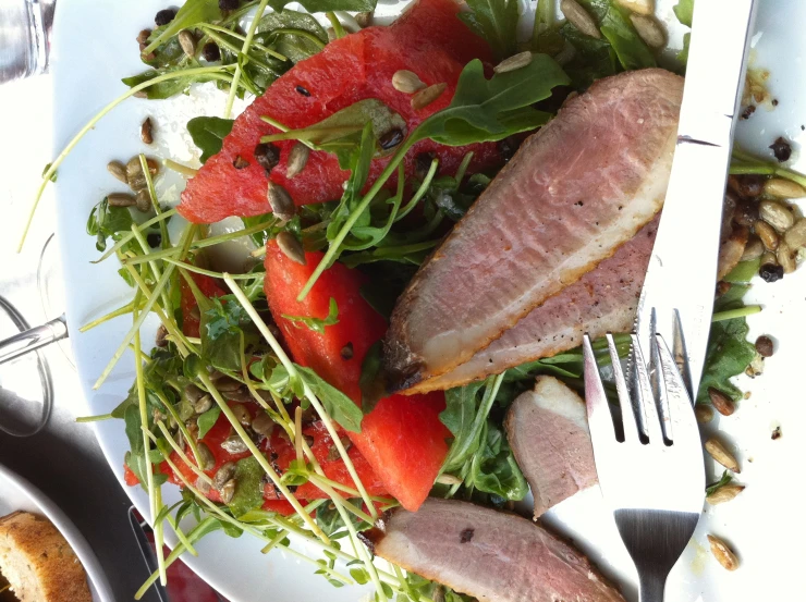 a white plate topped with meat and veggies