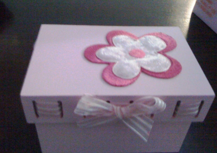 a pink gift box with a flower decorated on top