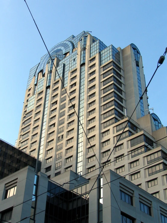 a large white building with glass windows sitting next to some buildings