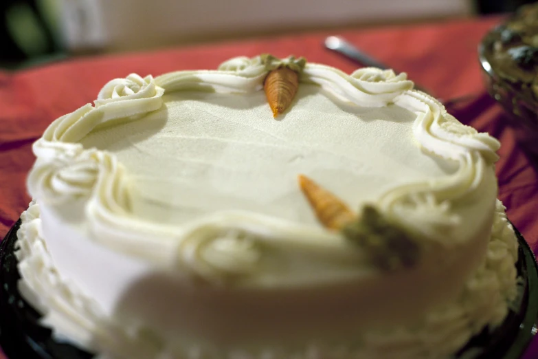 a white cake on a plate on a red table cloth