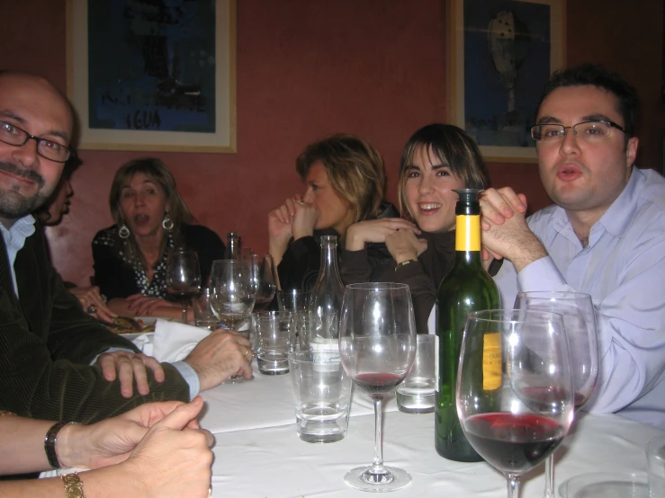 several people seated at a table drinking wine