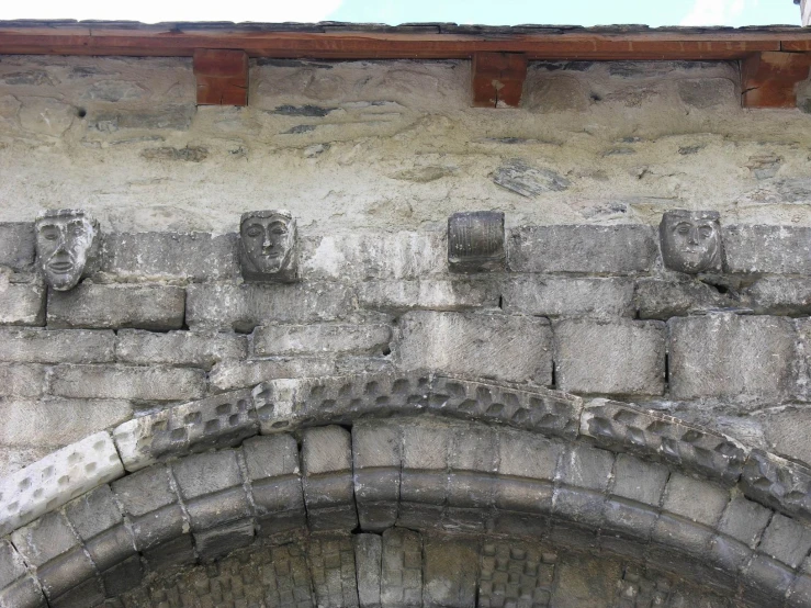 some statues are placed on a wall near a doorway