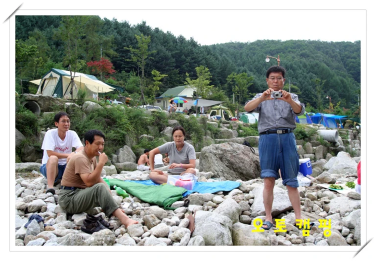 a man is standing on the rocks near some other men