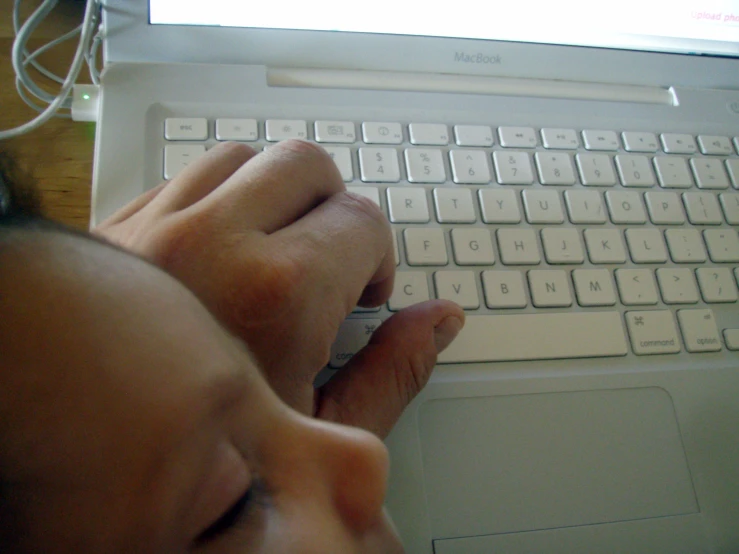 a person using a keyboard on top of a laptop