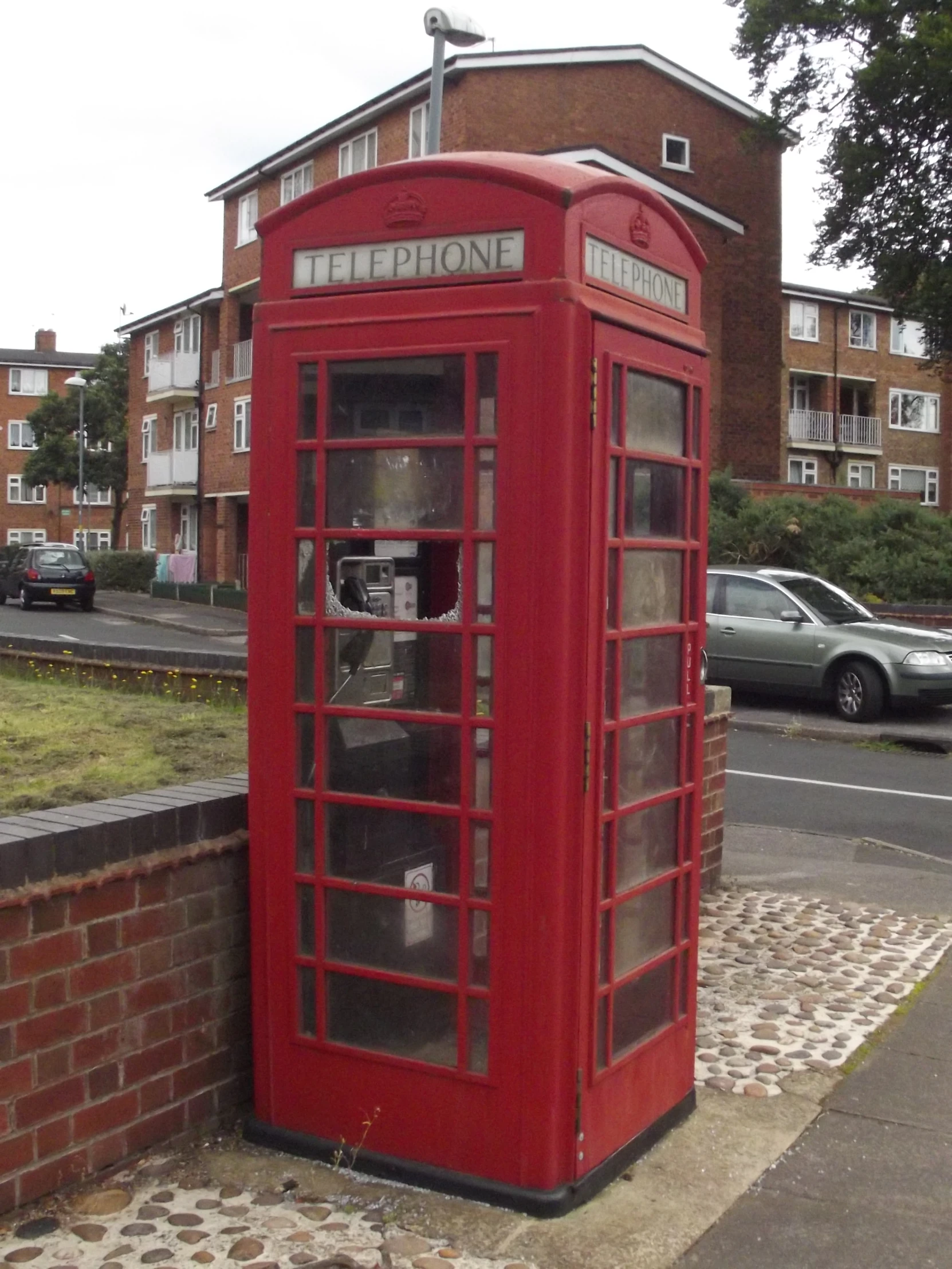 a red phone booth sitting on the side of a street