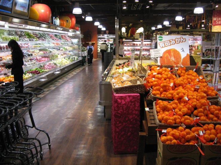a large produce aisle with oranges on each table