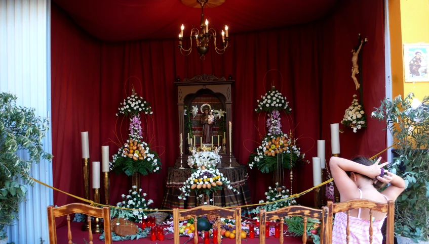 a woman is sitting in a chair beside the shrine