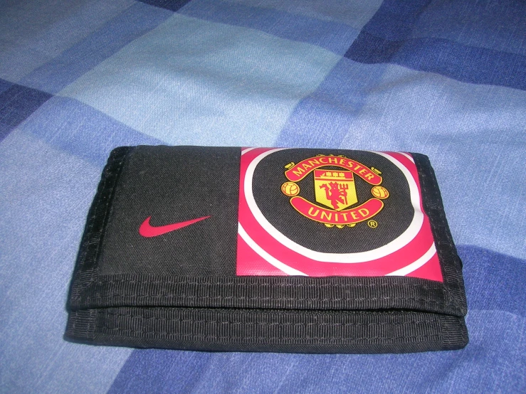 the nike black wallet has the manchester united crest on it