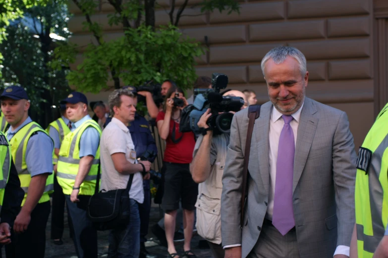 people standing around a man in a grey suit