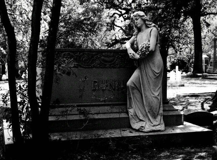 a woman sitting on a tombstone with her face touching her hand