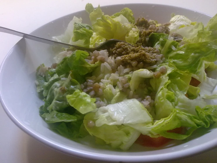 a large salad in a white bowl with an odd shape