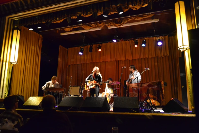 a band playing in an auditorium for a concert