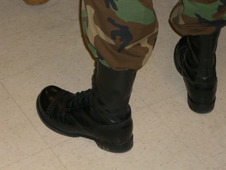 a man in camouflage pants and boots