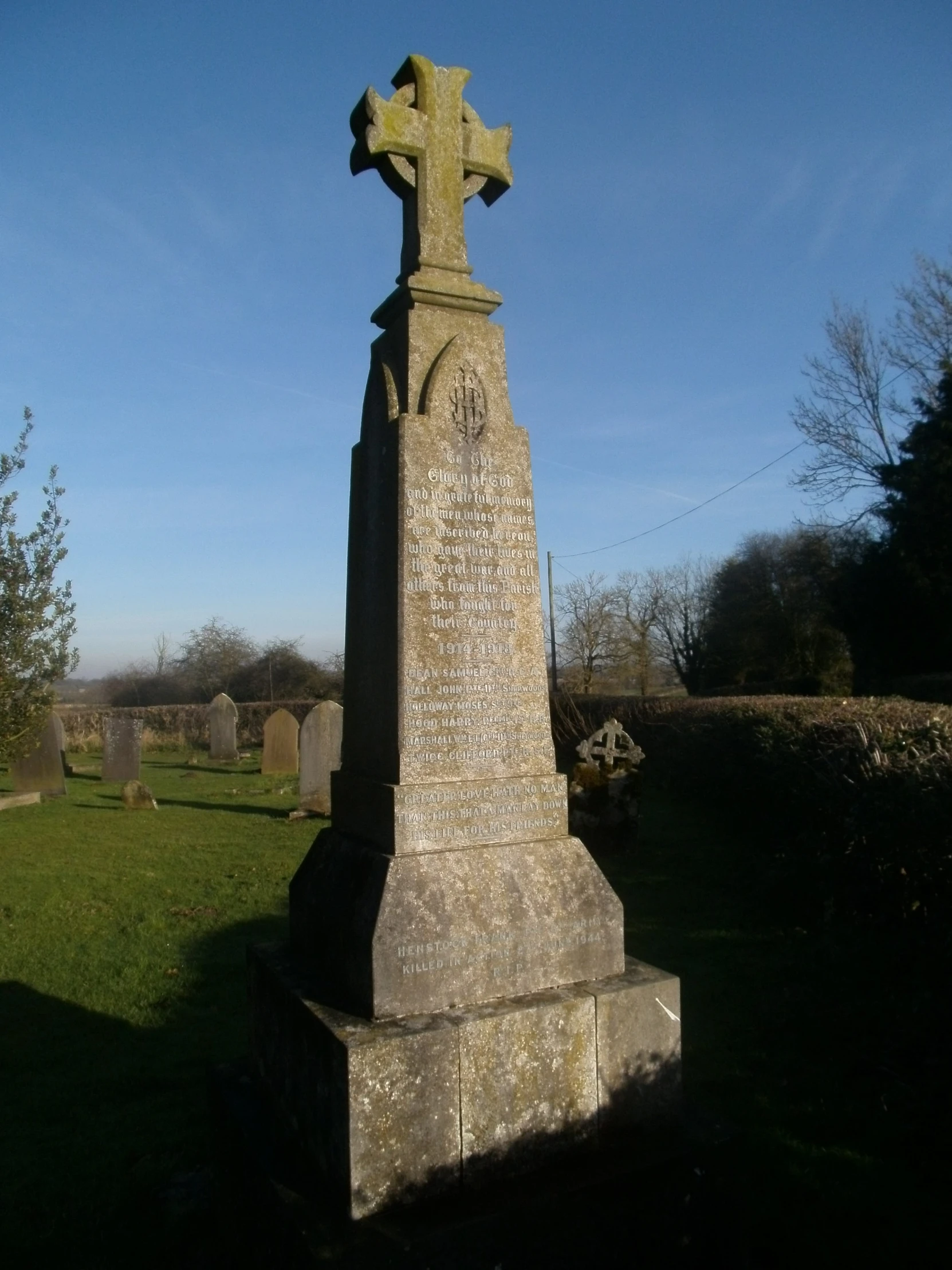 a stone cross standing in the grass