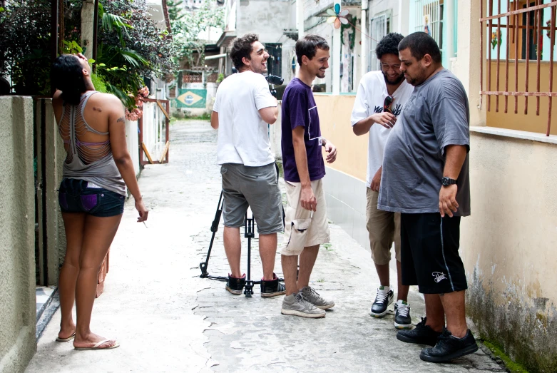 five friends are standing together and chatting while one person takes pictures