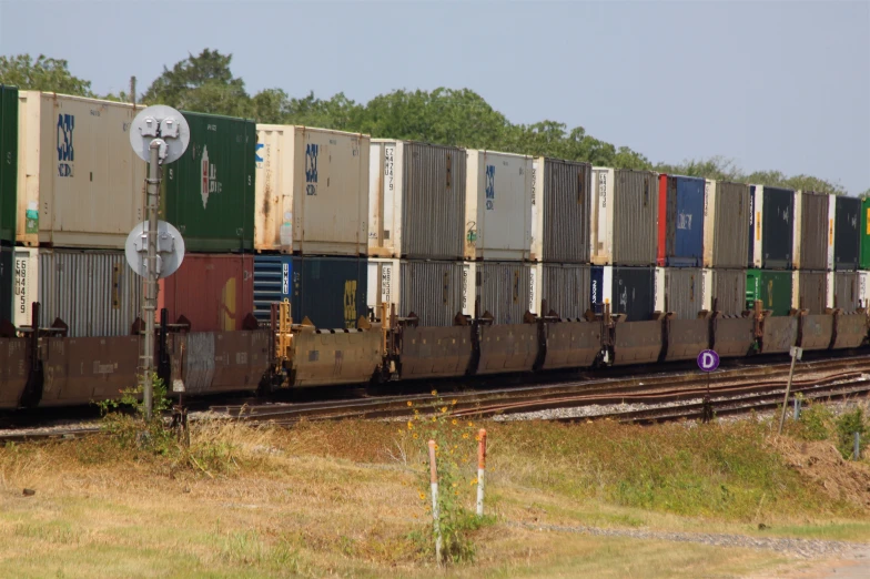 an industrial train with multiple cargo containers stacked on the front