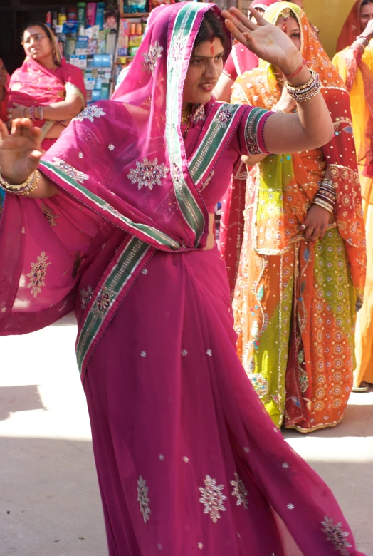 women in colorful sarees are performing a dance