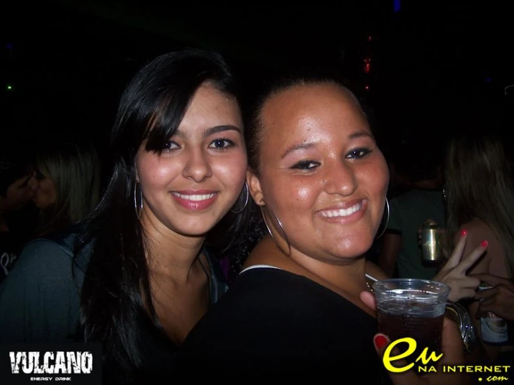 two girls smile at the camera with drinks