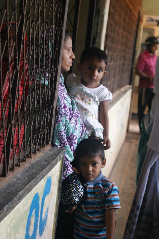 two s leaning against a railing as the adults look over the top