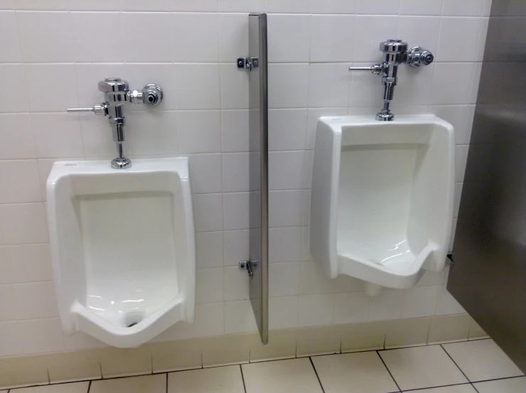 an image of two urinals in bathroom stall