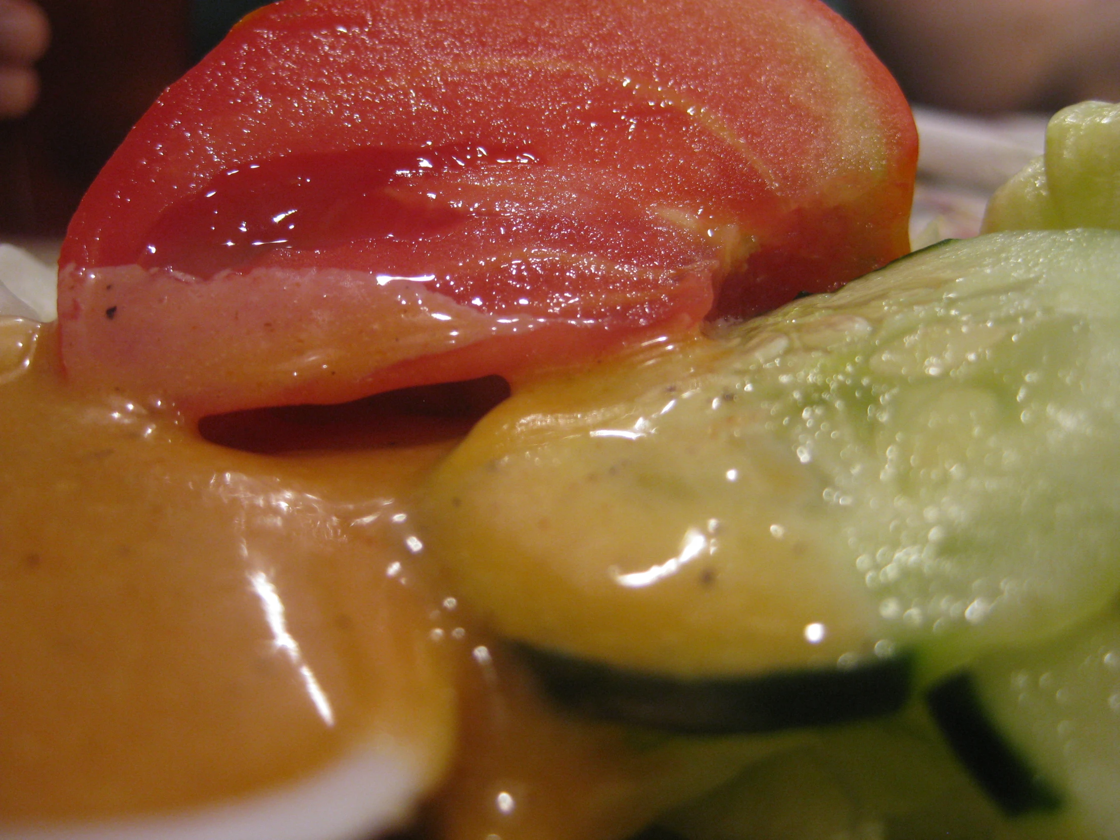 cucumber, tomato and sauce on a plate with green vegetables