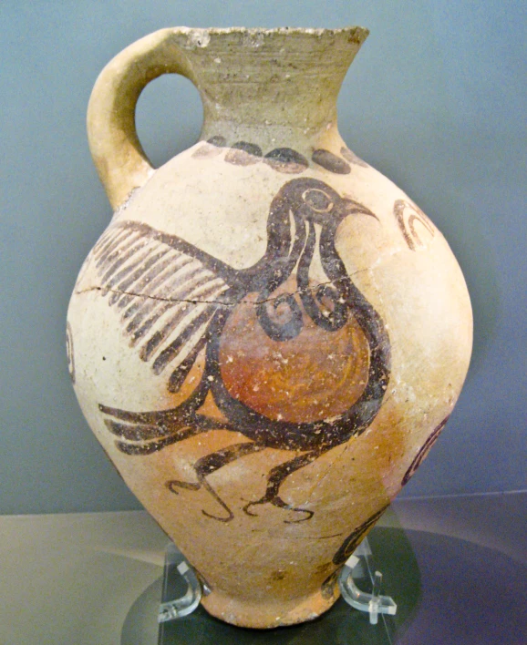 an antique vase depicting a bird on it's side