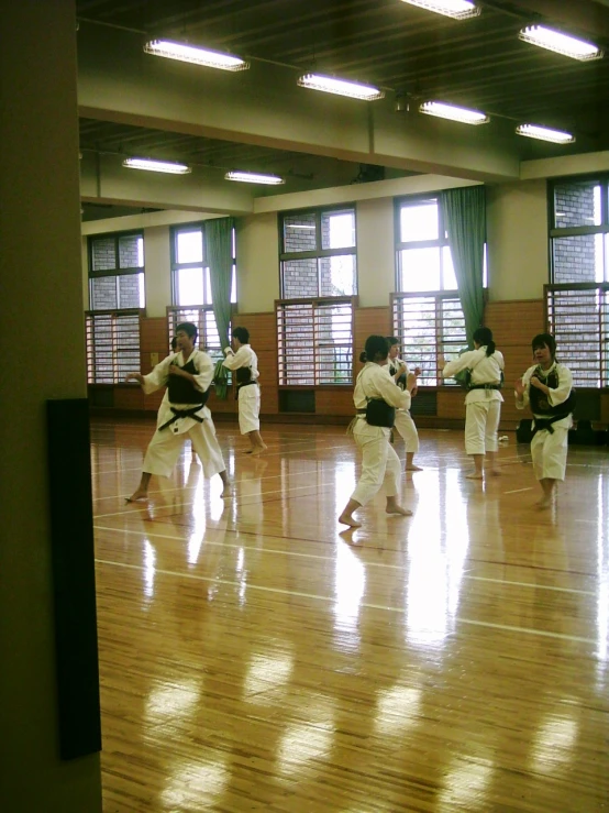 a group of people doing karate in an empty room