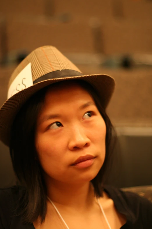 a woman wearing a hat while sitting on a couch