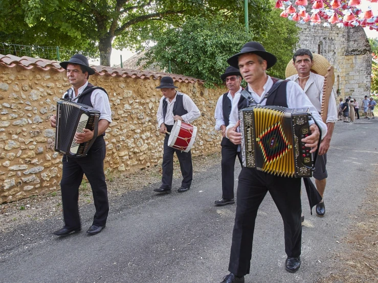 a group of men carrying a musical instrument next to a wall