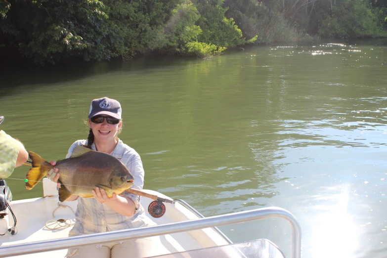 a person on a boat holding a fish