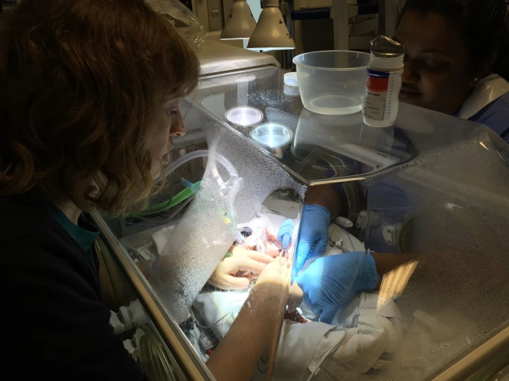 a woman in a white shirt and gloves preparing soing