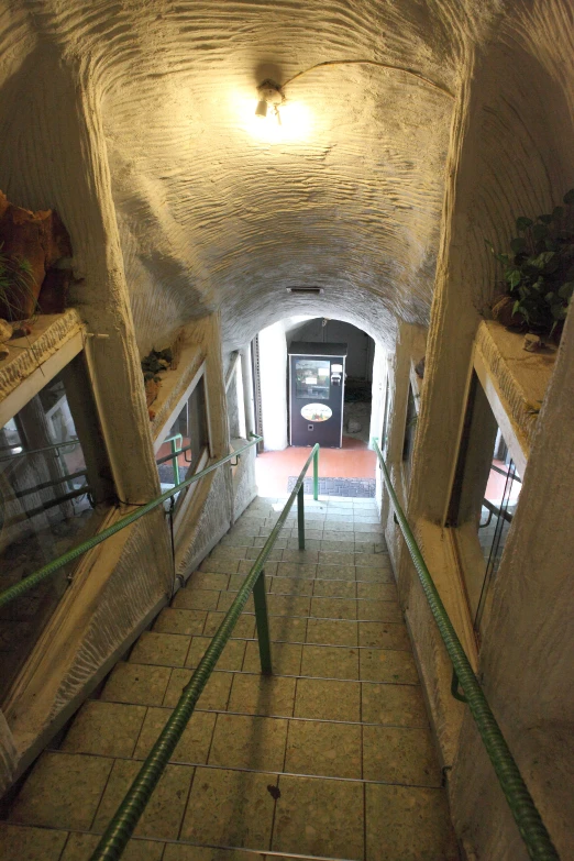 an empty cement tunnel with steps and railings