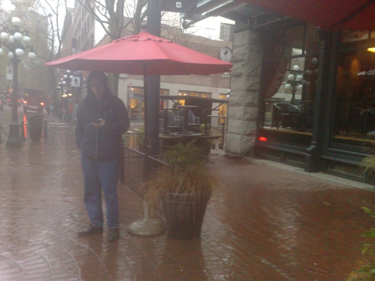 the girl is standing under the umbrella in the rain