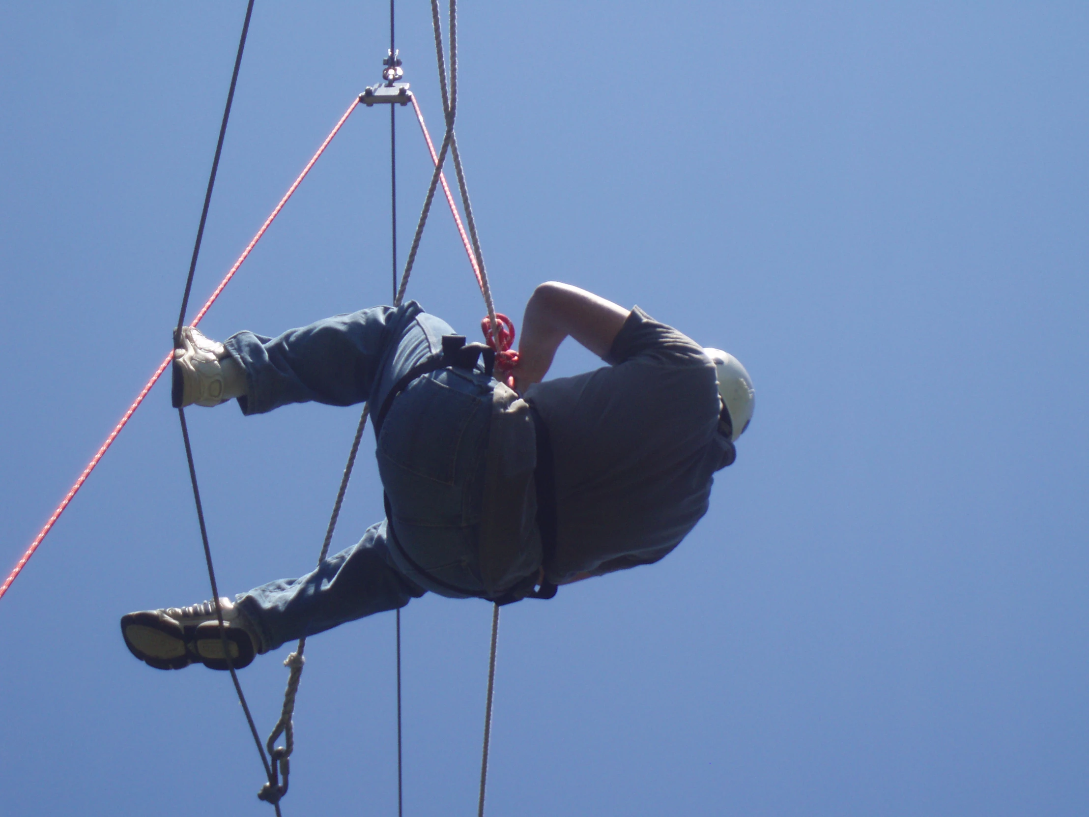 an electrician hangs off the side of a rope