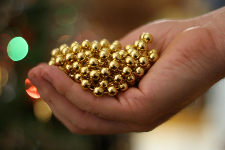 small balls with gold caps being held by a hand