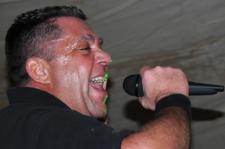 a man with a microphone is singing into soing