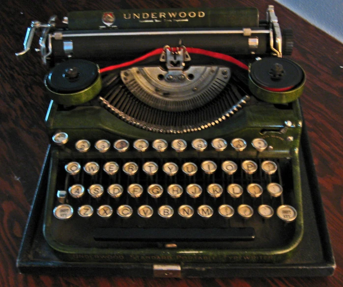 the antique typewriter sits on the table next to the mouse