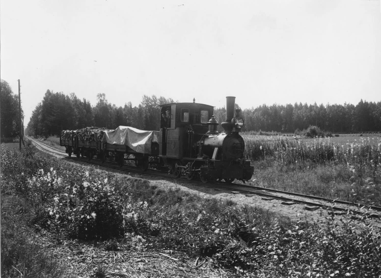 an old black and white pograph of a train traveling through the country