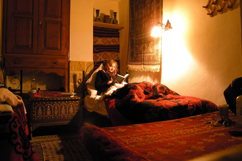 two children are sitting on a bed reading books