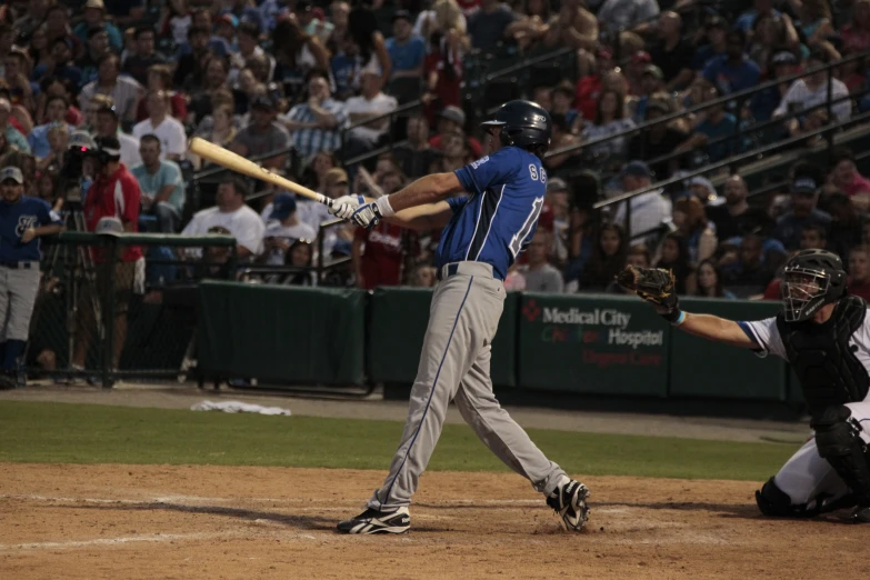 the man is swinging at the baseball as it's being hit by a pitch