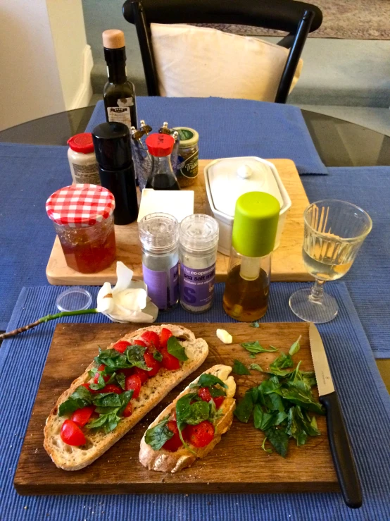 two sandwich halves on a wood board next to other food