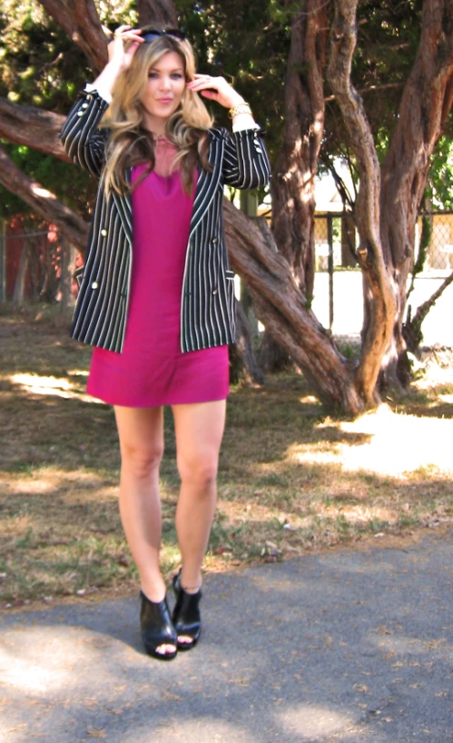 a woman in a pink dress and striped blazer