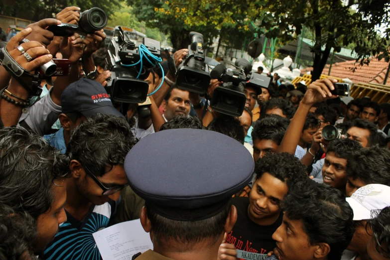 many people with cameras taking pictures or recording the events