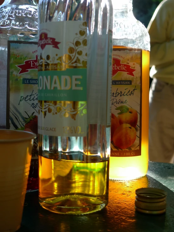 a bottle and a glass sit on a table