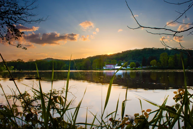 a beautiful sunrise reflects in the still water of a lake