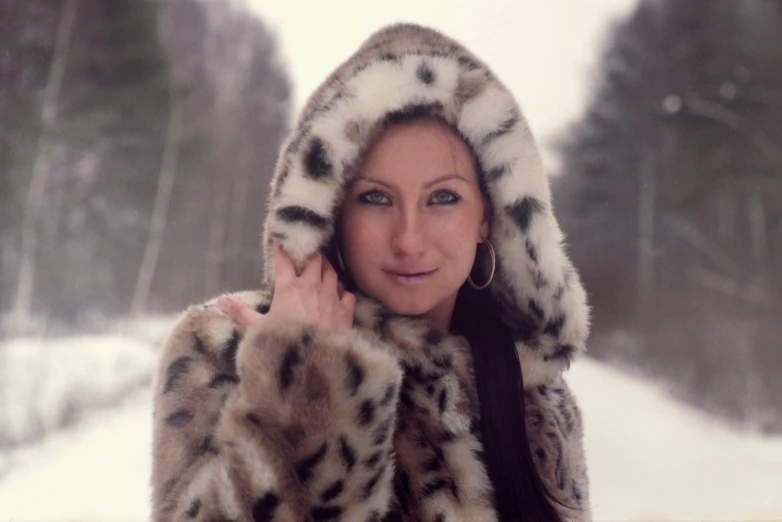 a woman in a leopard coat posing for a picture