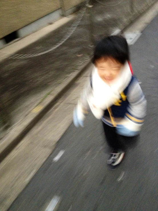 an blurry po of a boy on skateboard going down the street