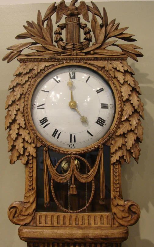 an old style carved clock is hanging from a wall