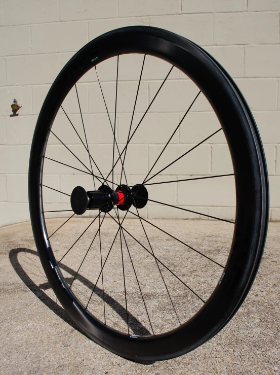 a bike tire on the ground next to a brick wall